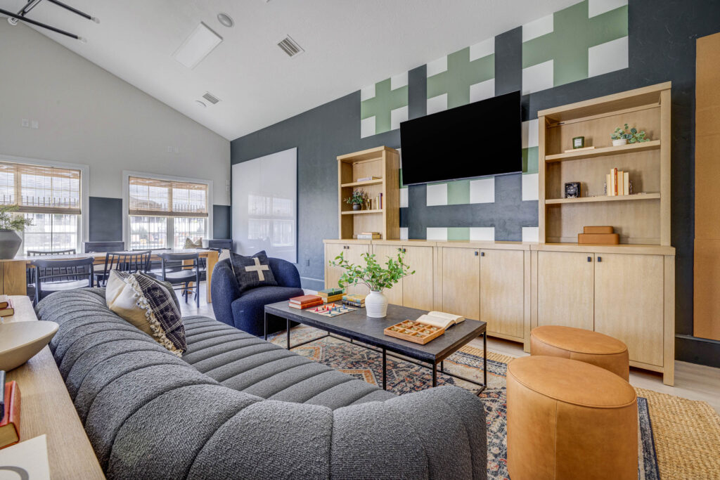 Clubhouse lounge with TV and large sofa at Copperwood apartments in Herriman, Utah.